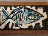 un tableau représentant un poisson, exposé dans un cadre en bois