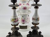 three candlesticks and a teapot sitting on a table
