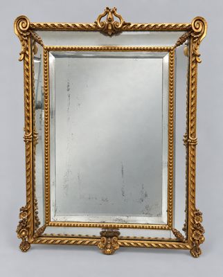 a gold framed mirror with a decorative design on the edge