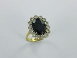 une bague en or sertie d'une pierre noire entourée de diamants blancs