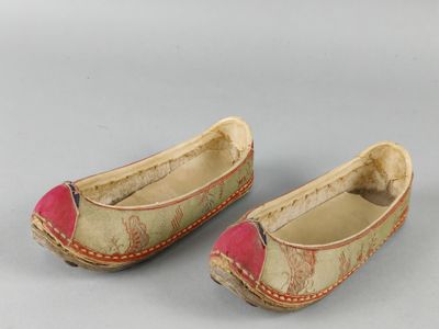 two pairs of slippers with red and white designs on them