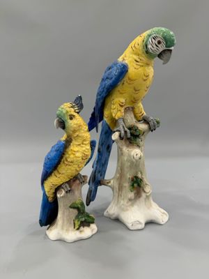 deux figurines représentant des perroquets perchés sur une souche d'arbre