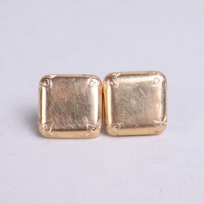 pair of gold tone square earrings on white background
