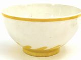 a yellow and white bowl on a white surface