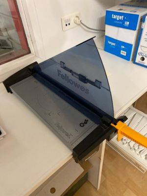 a paper cutter sitting on top of a desk next to a computer
