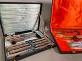 two sets of silverware in a case on the table
