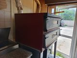 a red oven sitting in a kitchen next to a window