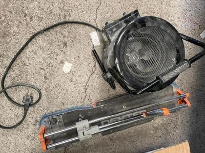 un petit ventilateur posé par terre à côté d'un morceau de bois