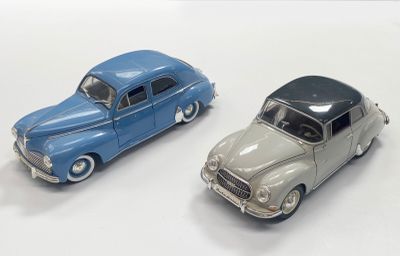 two toy cars sitting next to each other on a white surface