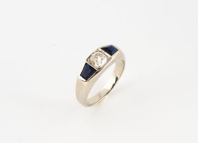 une bague en or blanc ornée d'un saphir et d'un diamant sertis au centre