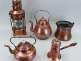 an assortment of antique copper teapots and kettles