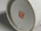 a white cup with a red design on it