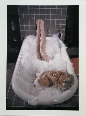 a picture of a woman laying in a bathtub with bubbles
