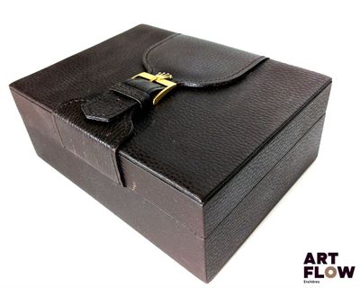 une boîte en cuir noir ornée d'une boucle dorée