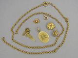 several pieces of gold jewelry including a necklace, broochle, and a broochle