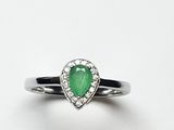 un gros plan d'une bague sertie d'une pierre verte en forme de poire