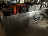 stainless steel counter top with pots and pans on it in a commercial kitchen