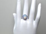 une main blanche portant une bague sertie d'un oplite
