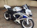 une moto blanche et bleue garée sur un parking