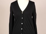 un cardigan noir boutonné, posé sur un mannequin
