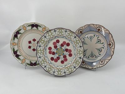 trois assiettes ornées de motifs sont posées sur une surface blanche