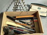 a box full of pens and pencils sitting on a table