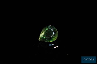 gros plan d'un diamant vert sur une surface noire