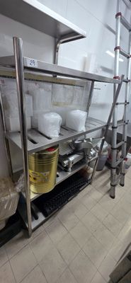 stainless steel shelvings in a commercial kitchen with pots and pans on them