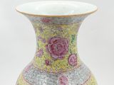 a yellow vase with pink flowers on it on a white background