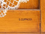 a close up of a white lace doily on a wooden door