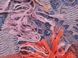 a close up picture of a multicolored scarf with a flower on it
