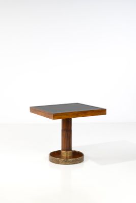 une petite table carrée avec un piètement en bois et un plateau noir