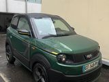 une petite voiture verte garée au bord de la rue