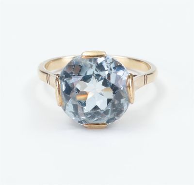 a gold ring with a blue topaz stone in the center