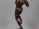 a bronze statue of a man holding a baseball bat