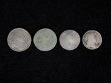 three silver coins sitting on top of a black surface