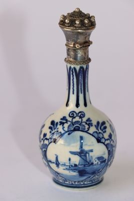 une petite bouteille bleue et blanche sur laquelle figure l'image d'un bateau