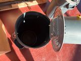 a black bucket with a metal strainer inside of it