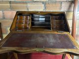 a wooden desk with drawers and a brick wall