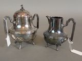 a silver tea pot and a silver coffee pot on a table