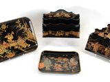 quatre plateaux décorés de noir et d'or sur un fond blanc