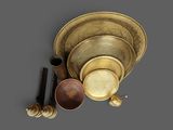an assortment of brass objects including a bowl, spoon, and other items