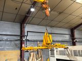a crane that is lifting a large piece of metal