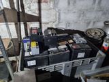 beaucoup de batteries empilées sur une palette dans un garage