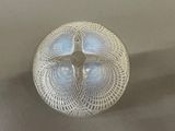 a silver plate with a cross on it on a table