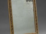 an antique mirror with a gold frame on a grey background