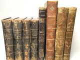 plusieurs vieux livres sont alignés sur une surface blanche