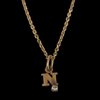 a gold initial necklace with a diamond on a chain