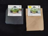 two bags of herbs are sitting on a black surface