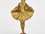 statue en laiton représentant une femme vêtue d'un tutu, posée sur un socle
